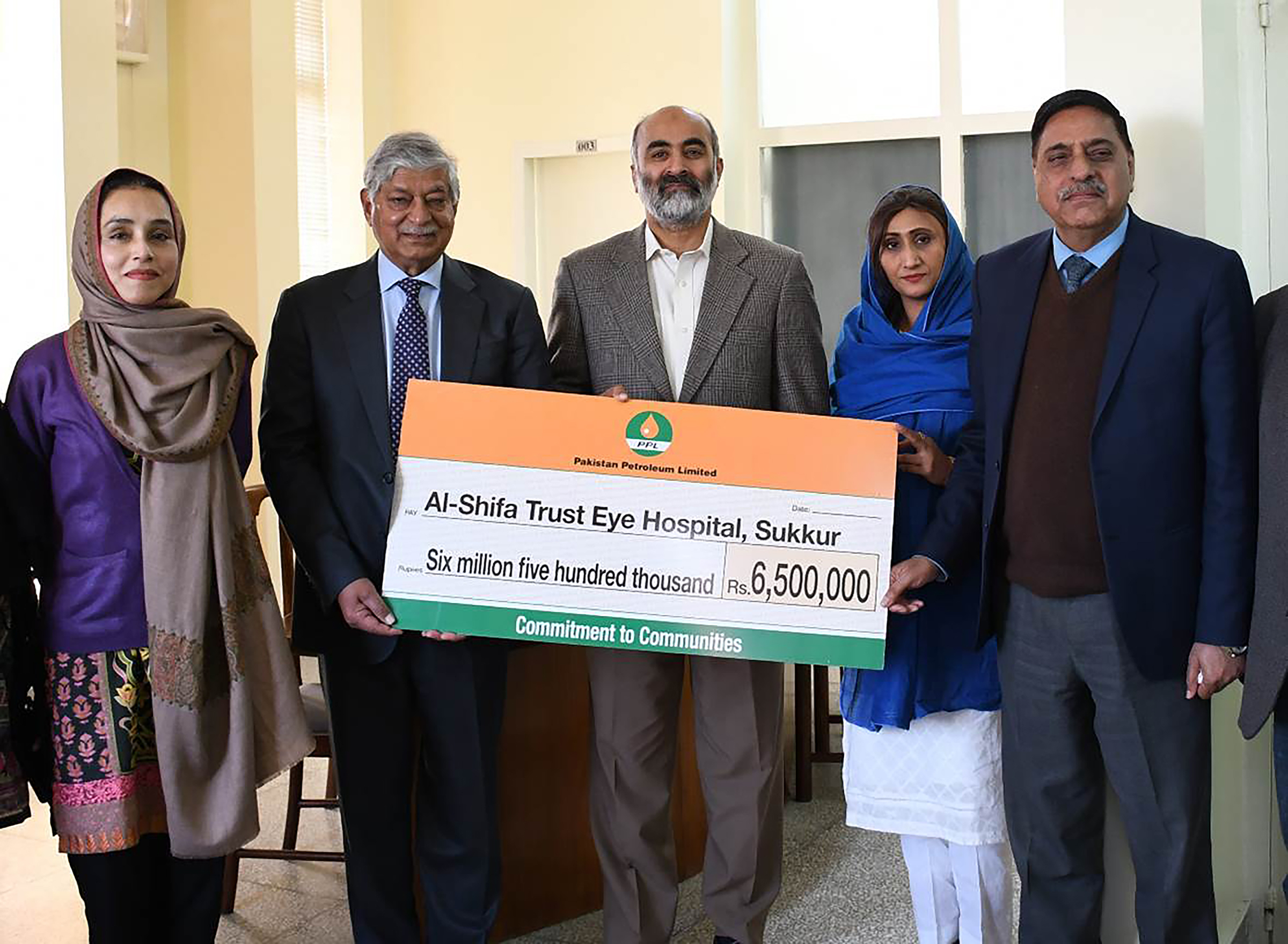 Community Development staff hands over a donation cheque to Al-Shifa Trust Eye Hospital for purchase of equipment 