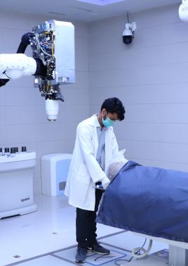 A patient being helped on CyberKnife technology equipment donated by PPL to Patients Aid Foundation for treatment of cancer patients at Jinnah Postgraduate Medical Center