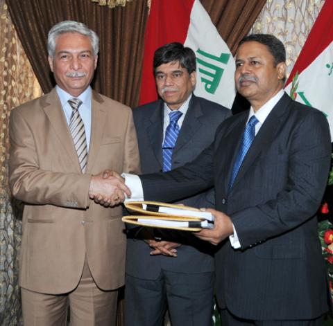 Director General Petroleum Contracts and Licensing Directorate Ministry of Oil Iraq Abdul Mahdy-al-Ameedi and SMBD Abdul Wahid exchange initial contract documents for Block 8 signed on July 15 2012 in Baghdad Iraq. SME Hayat Ahmad is also present